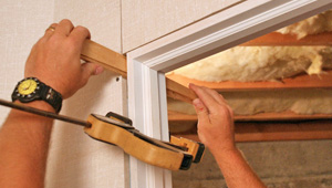 Installing trim and finishing touches to a remodeled basement in Nashua, MA & NH
